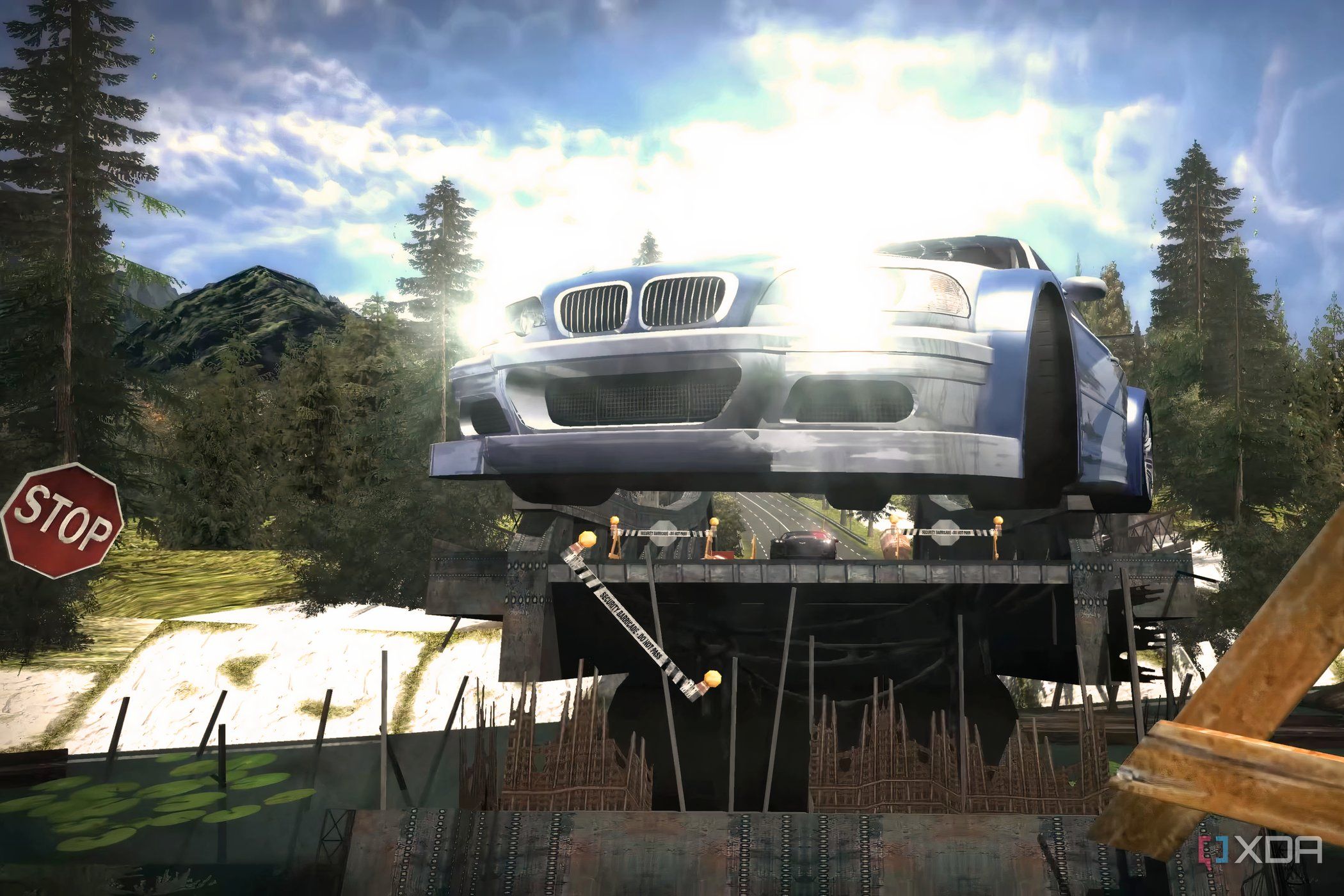 A screenshot from Need for Speed: Most Wanted showing a blue and white BMW M3 GTR jumping over a bridge with its headlights on.