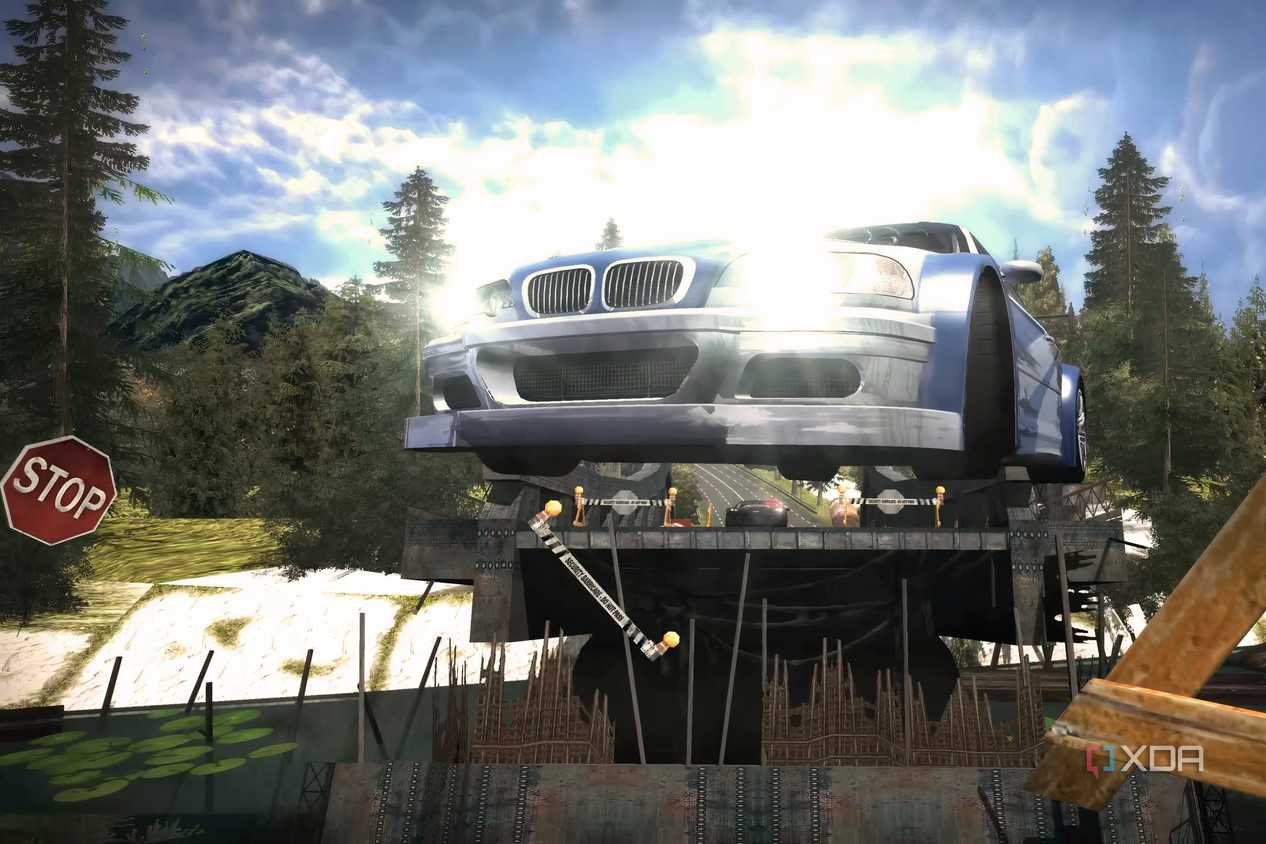 A screenshot from Need for Speed: Most Wanted showing a blue and white BMW M3 GTR jumping over a bridge with its headlights on.