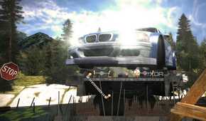 A screenshot from Need for Speed: Most Wanted showing a blue and white BMW M3 GTR jumping over a bridge with its headlights on.