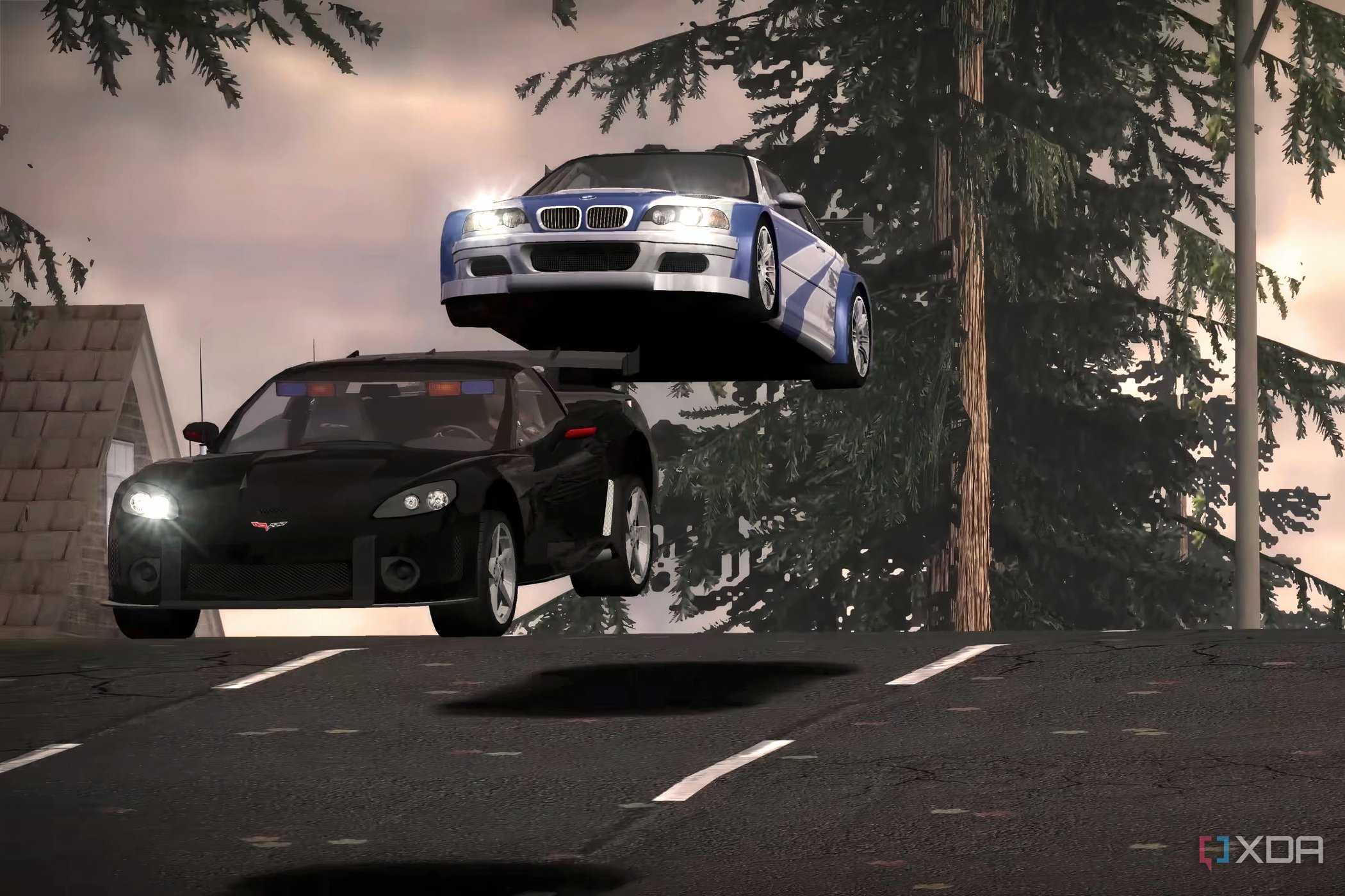 A screenshot from Need for Speed: Most Wanted 2005, showing a white and blue BMW jumping over a black Corvette.