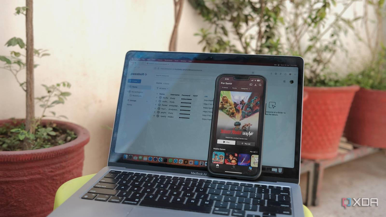 A photo of a laptop running password management software with a mobile 