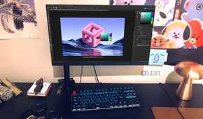 Photoshop displayed on desktop pc with posters,lamp, and headphones in view