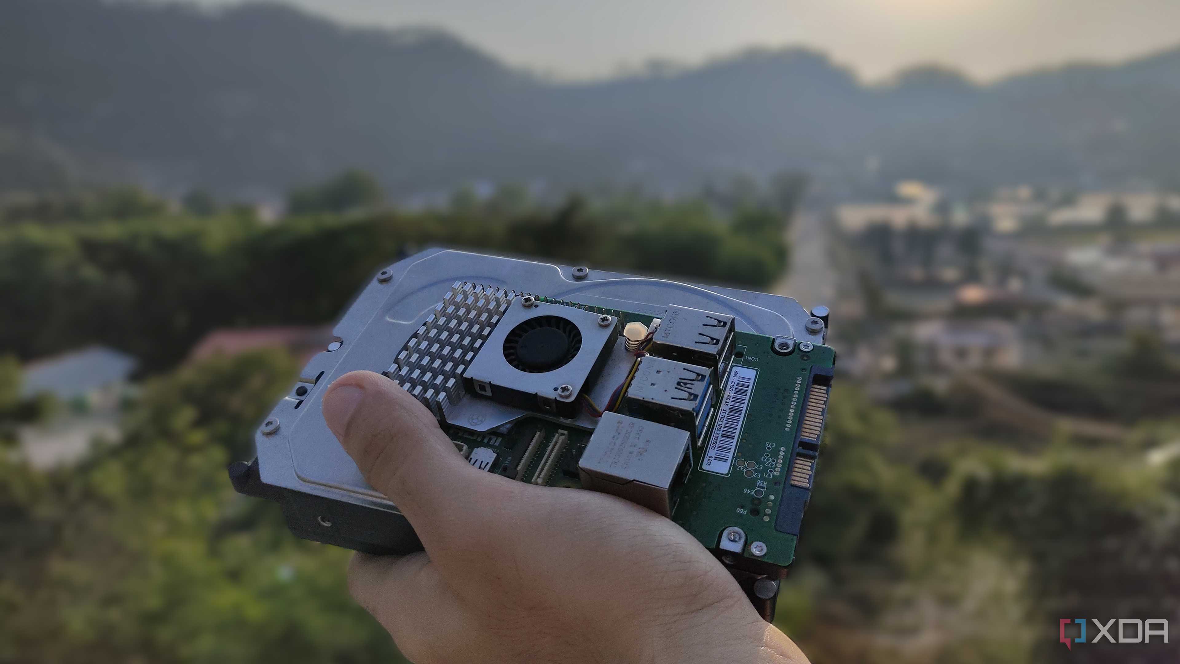 A person holding a Raspberry Pi and some storage drives