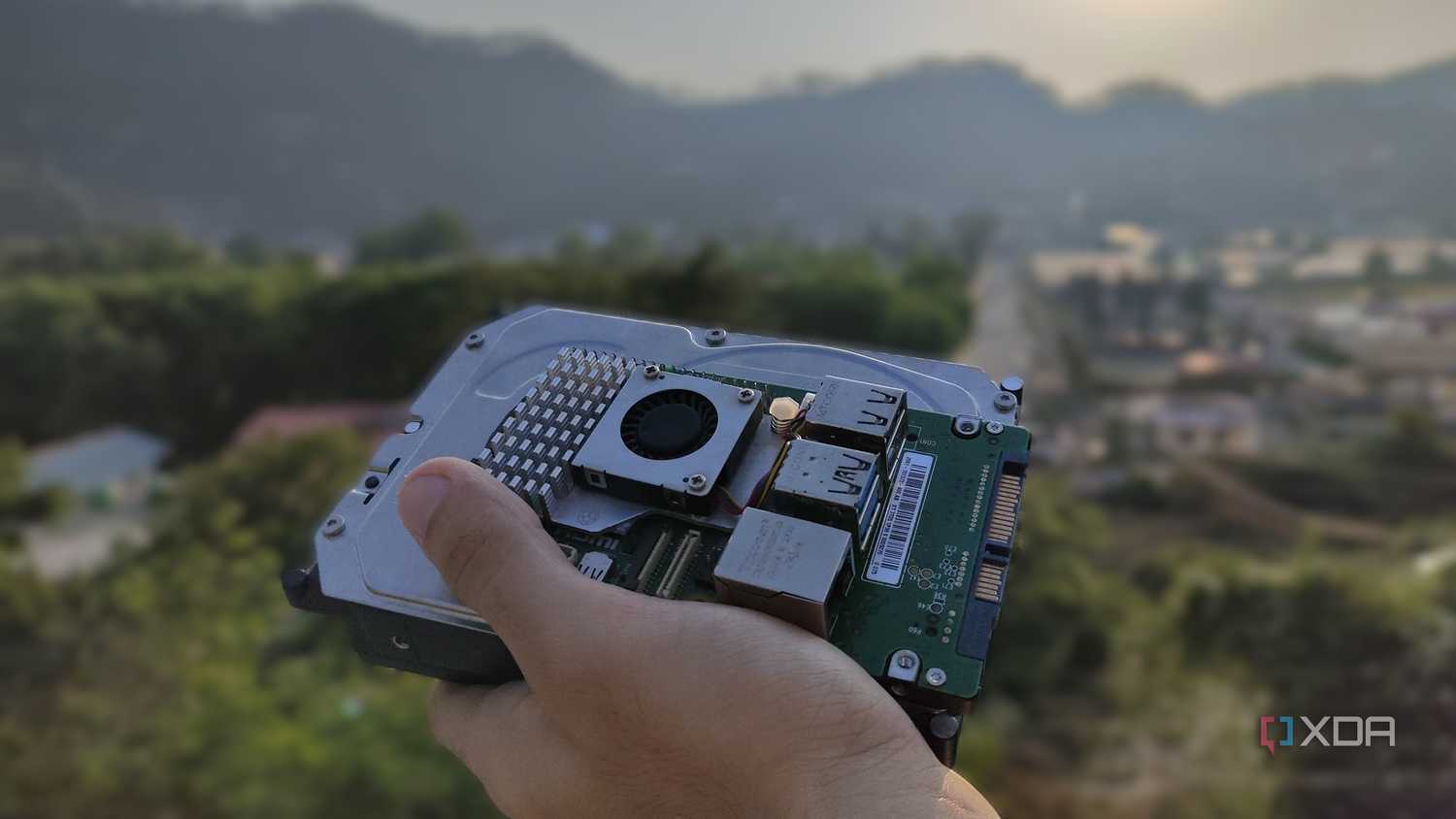 A person holding a Raspberry Pi and some storage drives