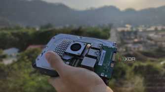 A person holding a Raspberry Pi and some storage drives