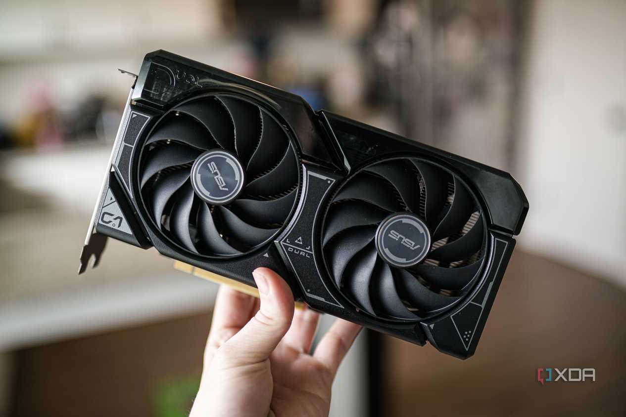 A hand holding the Nvidia RTX 4060 GPU.