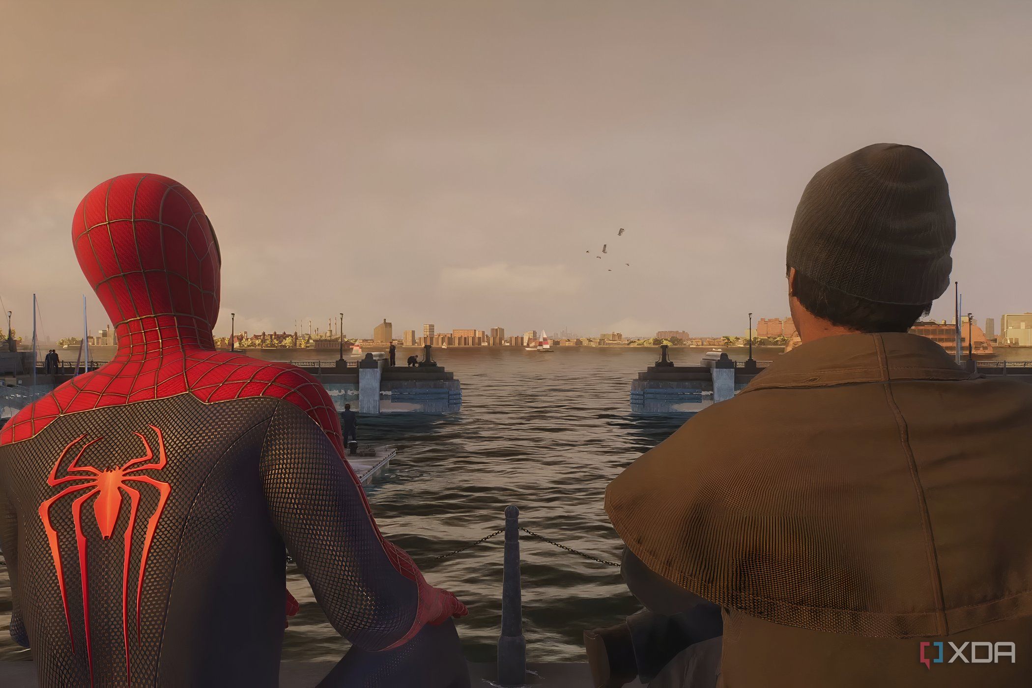 A screenshot from Marvel's Spider-Man 2, showing Spider-Man sitting down at the riverfront with a friend.
