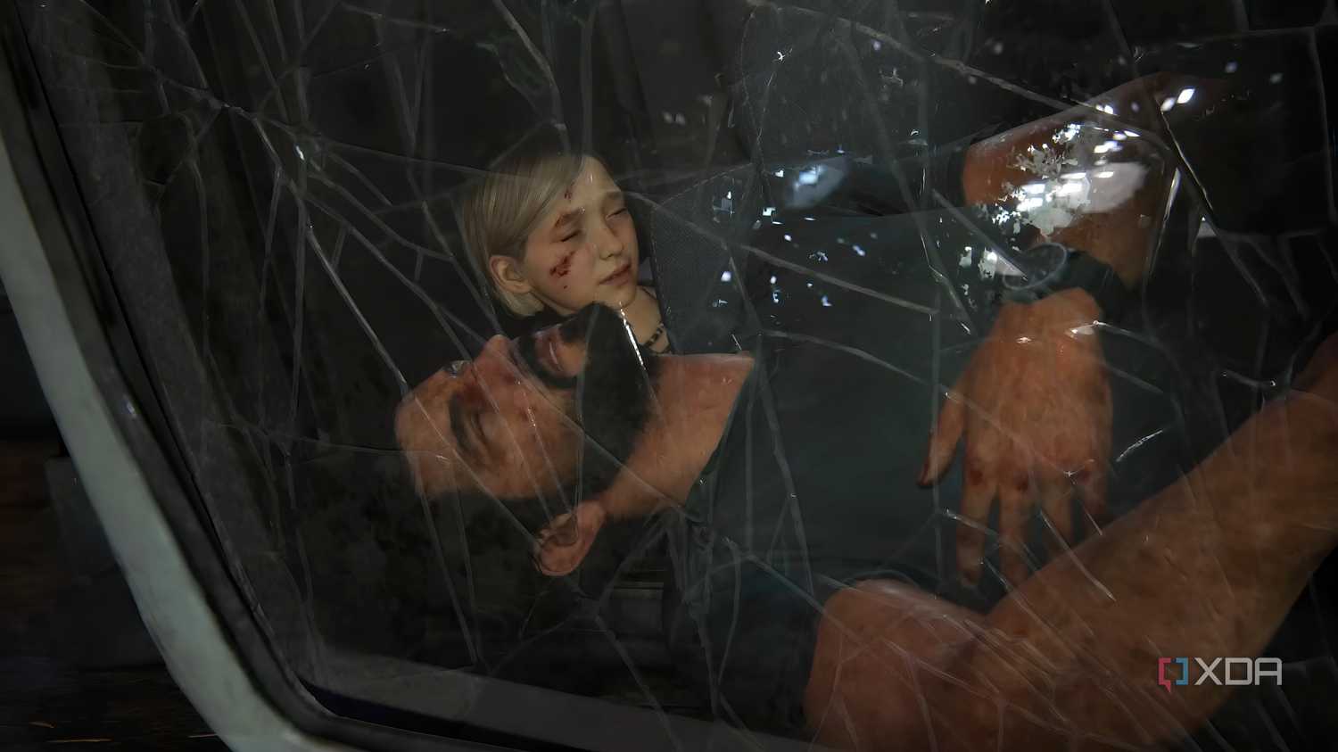 A screenshot from The Last of Us Part I on PC, showing Joel unconscious in a car through a cracked windshield, while his daughter Sarah is behind him, coming to.