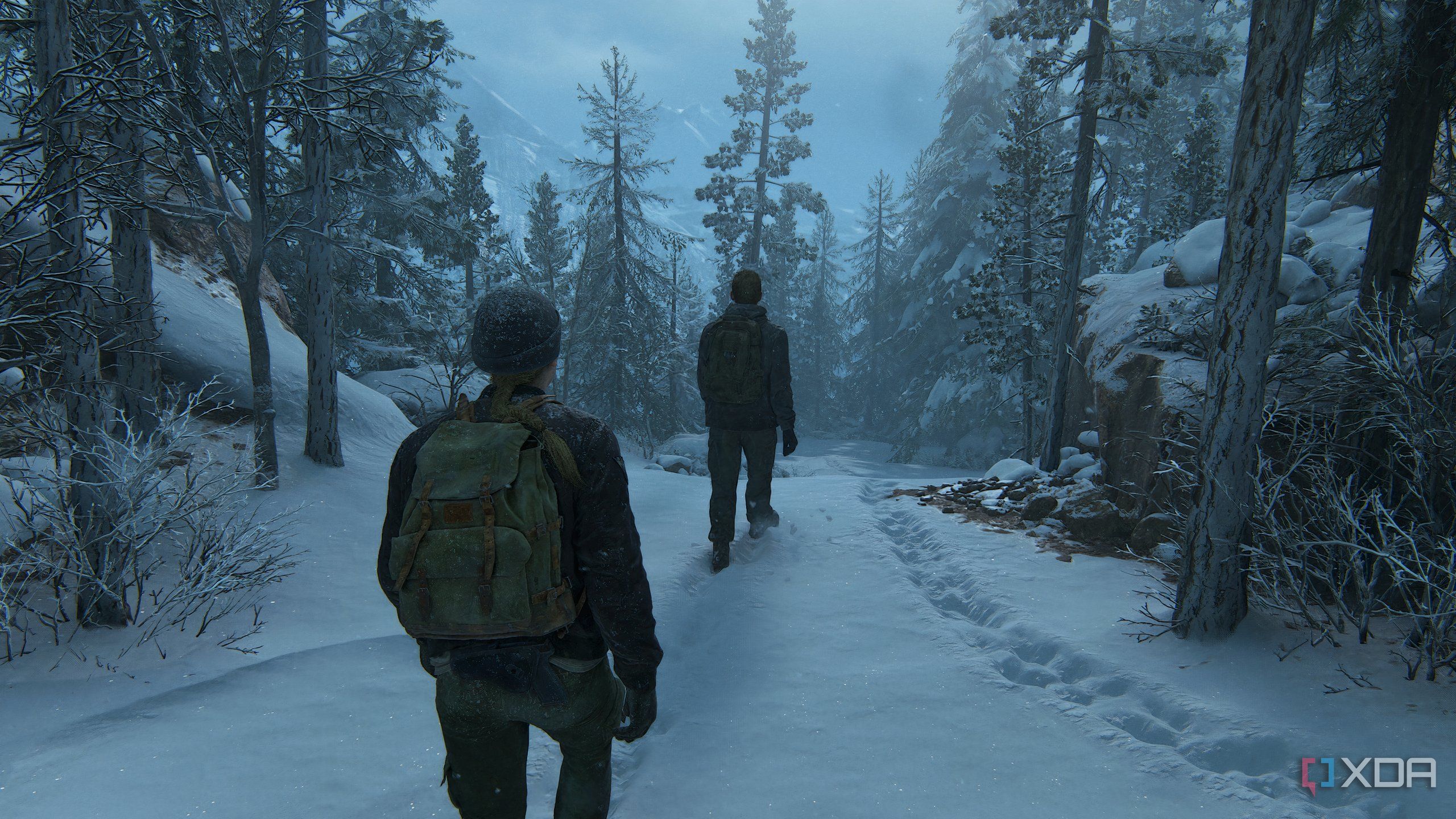 A screenshot from the game The Last of Us Part II Remastered on PC, showing Abby and Owen walking through snow.