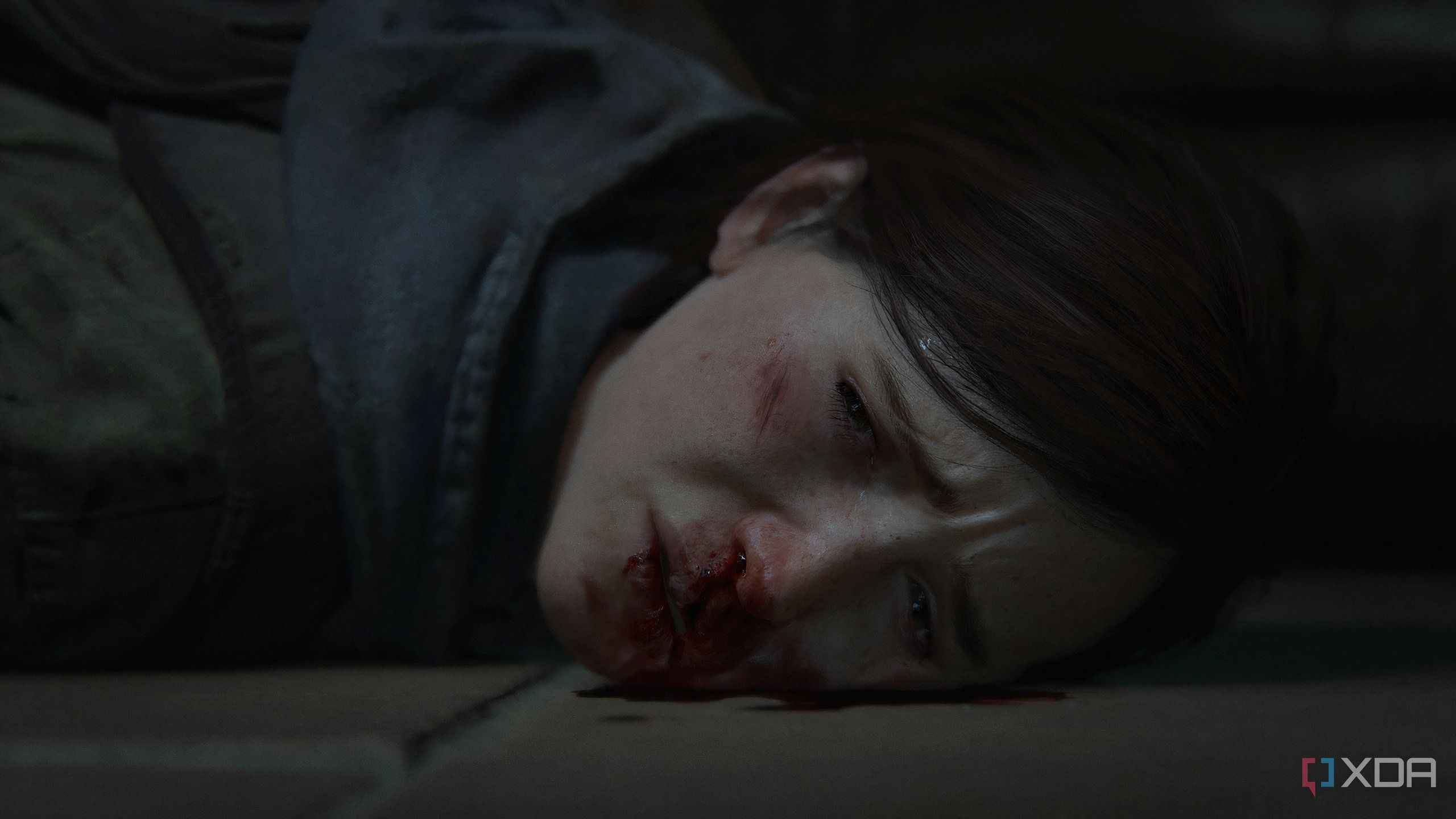 A screenshot from the game The Last of Us Part II Remastered on PC, showing Ellie's face bloodied.