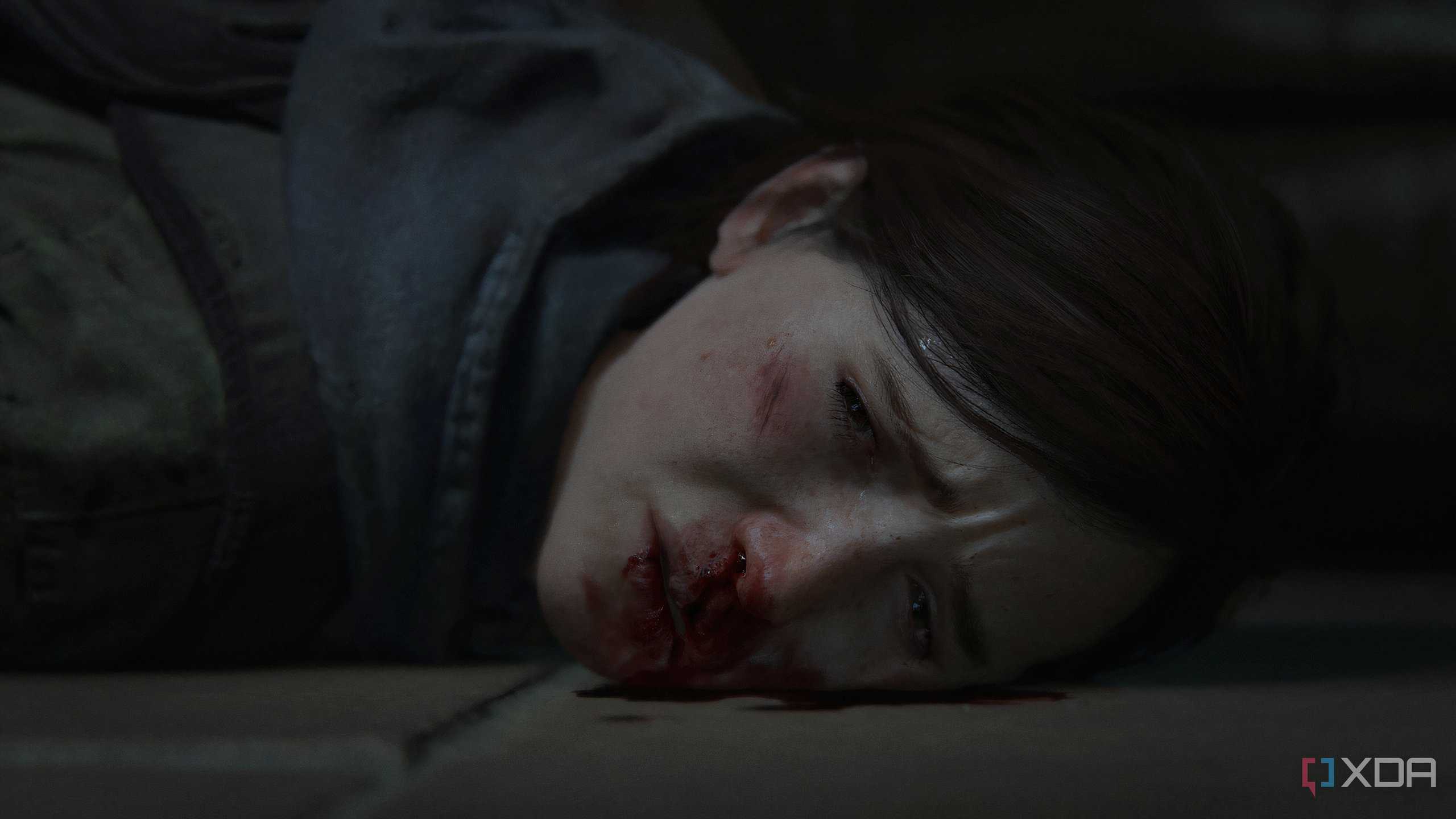 A screenshot from the game The Last of Us Part II Remastered on PC, showing Ellie's face bloodied.