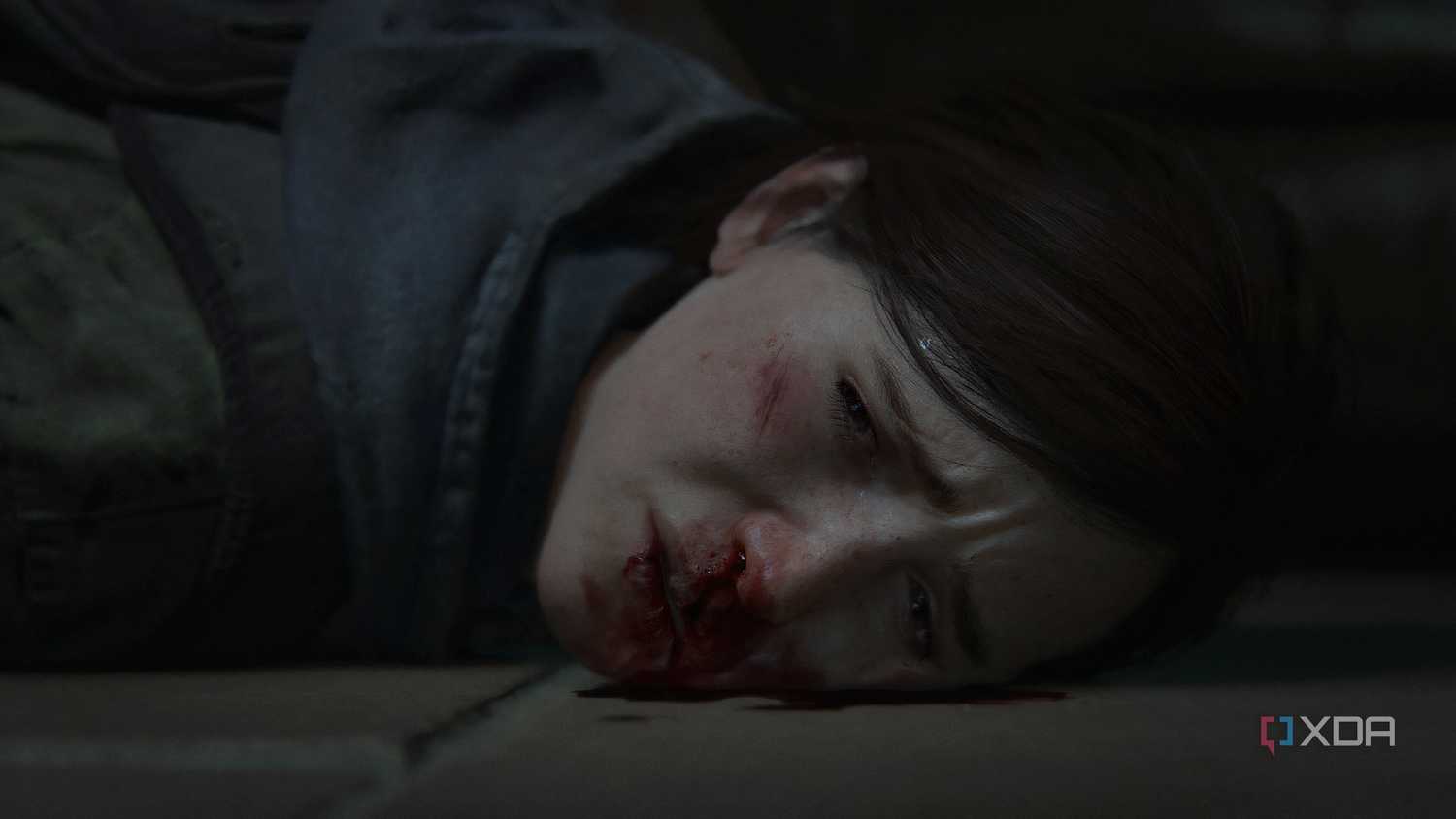 A screenshot from the game The Last of Us Part II Remastered on PC, showing Ellie's face bloodied.