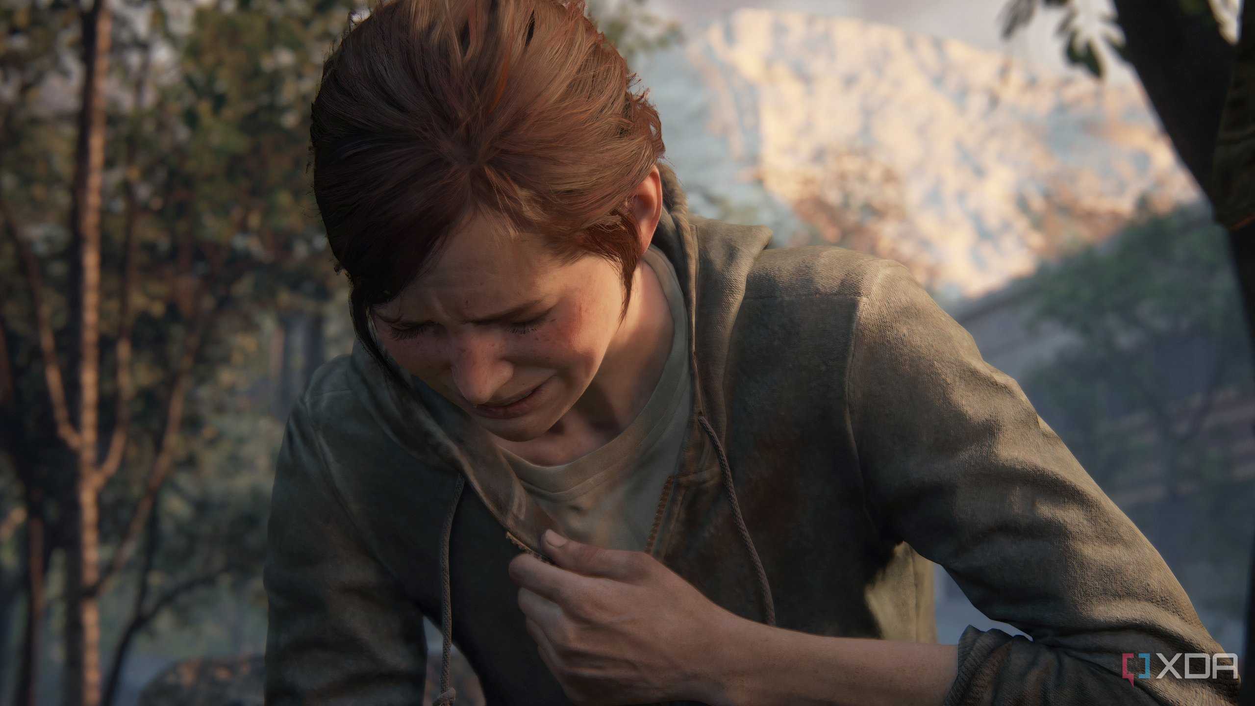 A screenshot from the game The Last of Us Part II Remastered on PC, showing Ellie crying and clutching her chest.
