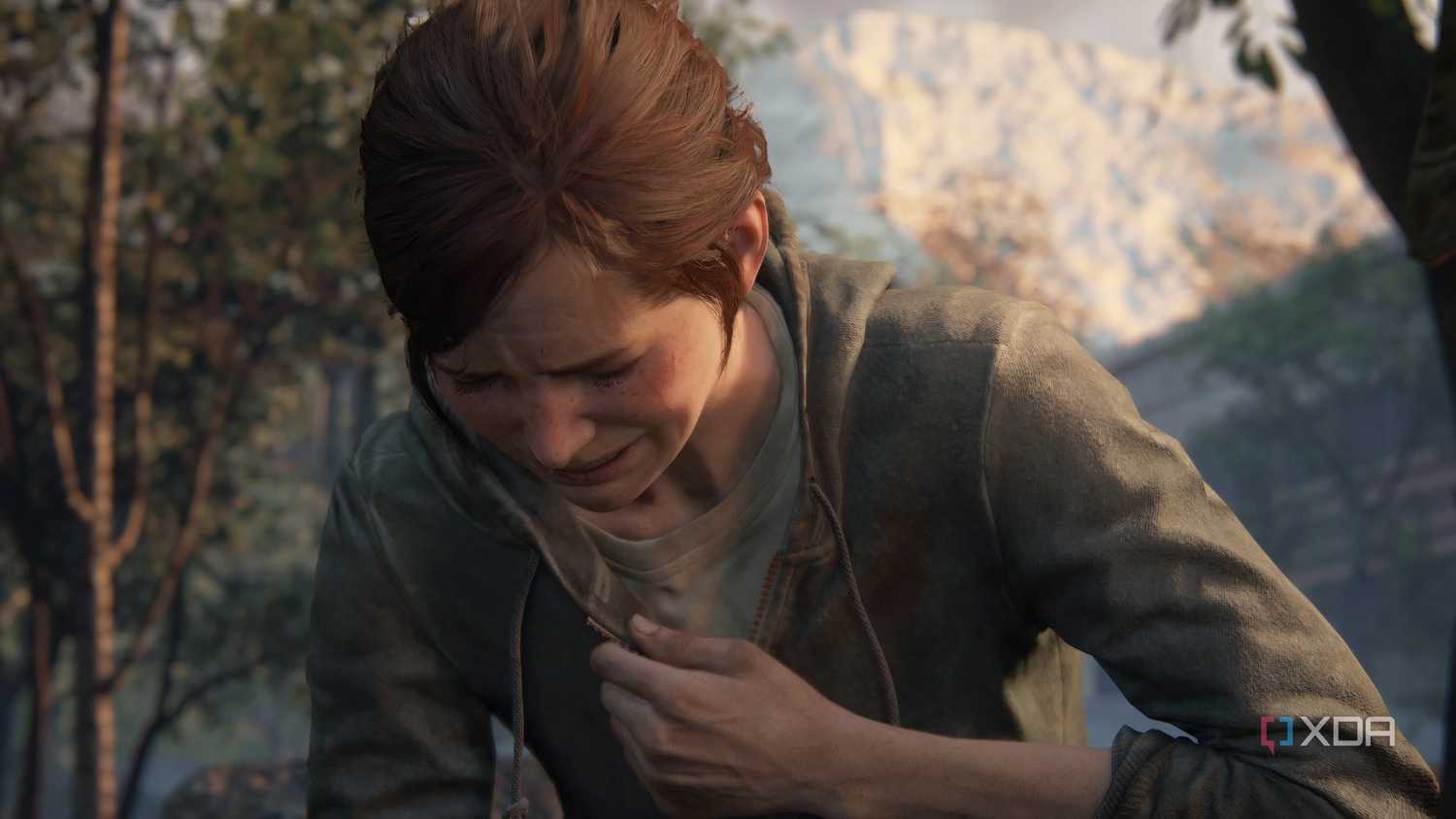A screenshot from the game The Last of Us Part II Remastered on PC, showing Ellie crying and clutching her chest.