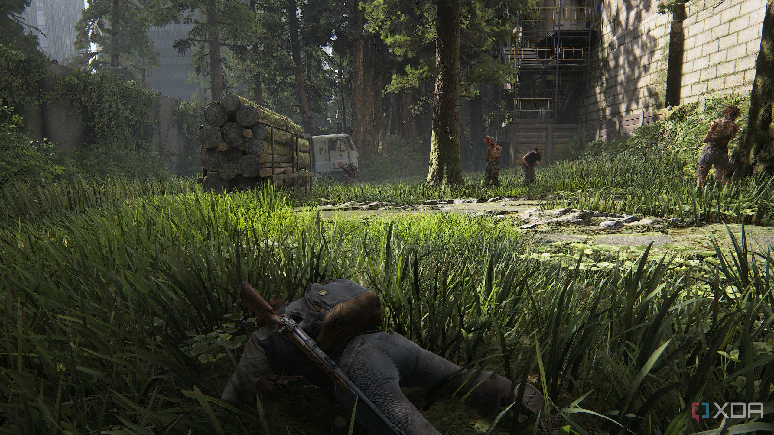 A screenshot from the game The Last of Us Part II Remastered on PC, showing Ellie crawling through grass as zombies stand around her.