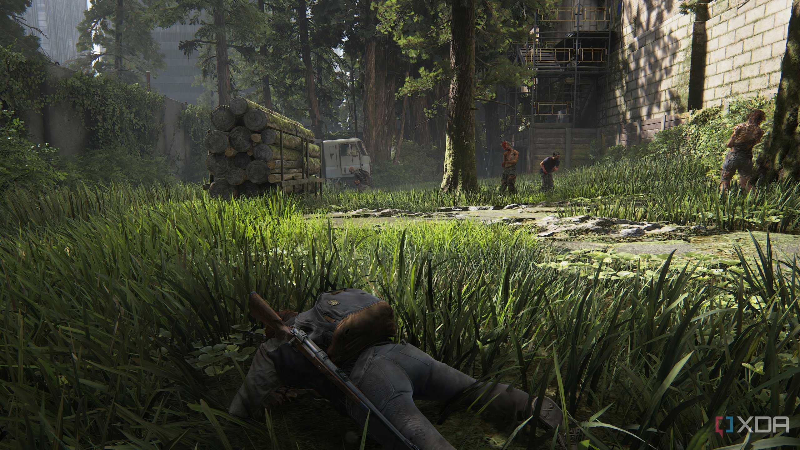 A screenshot from the game The Last of Us Part II Remastered on PC, showing Ellie crawling through grass as zombies stand around her.