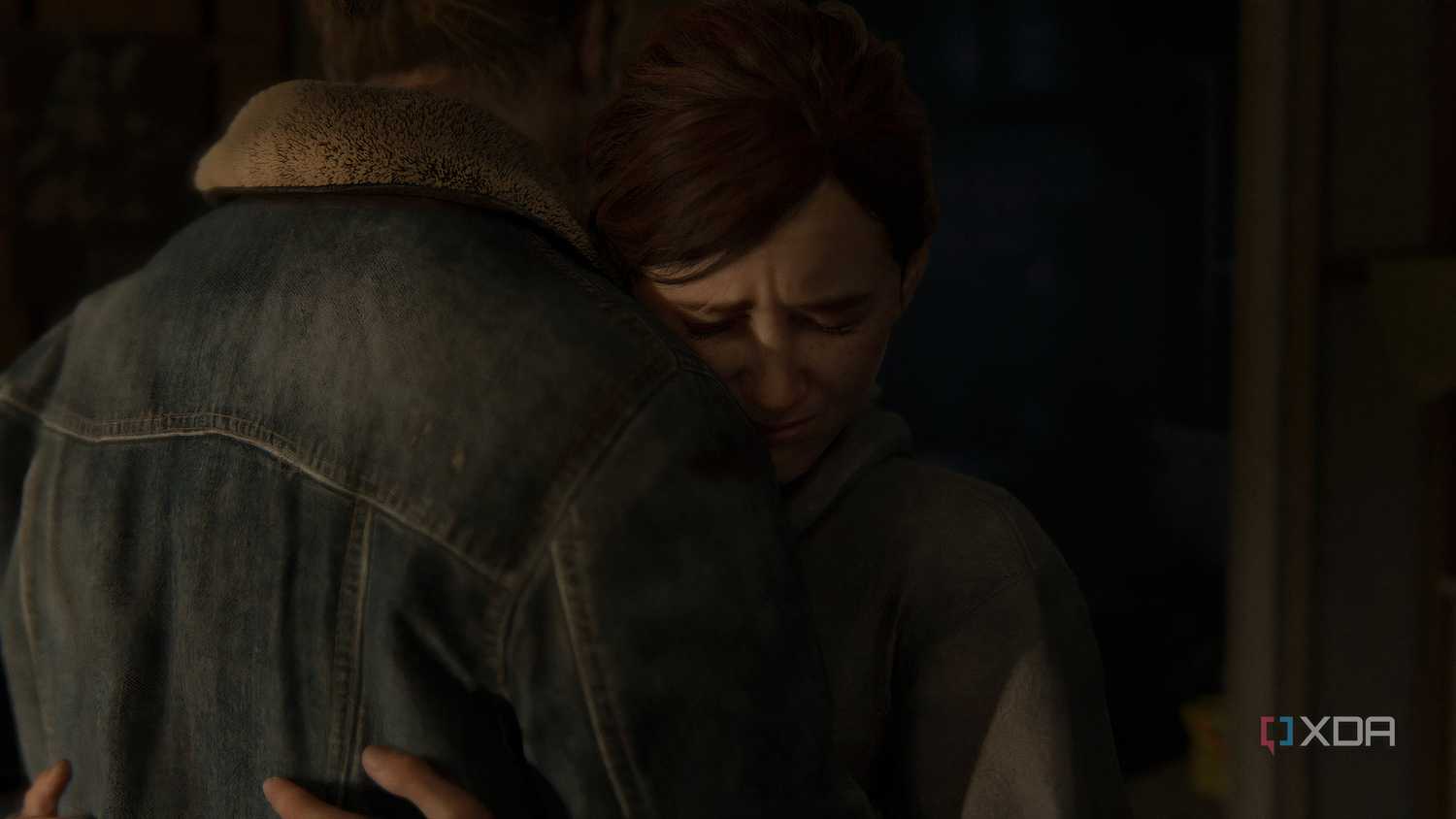 A screenshot from the game The Last of Us Part II Remastered on PC, showing Ellie hugging Tommy.