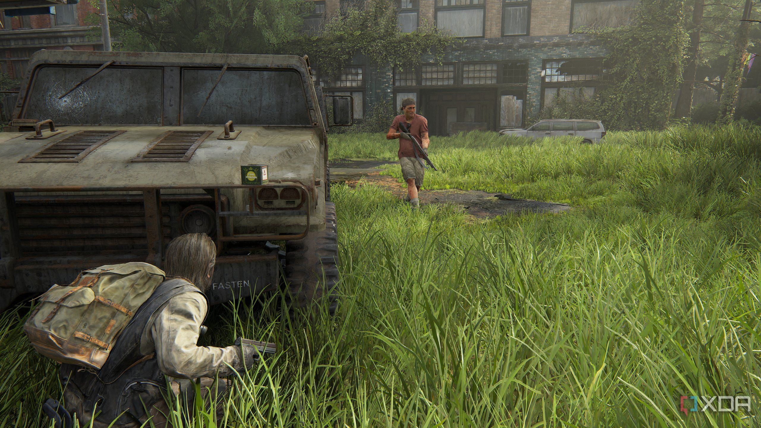 A screenshot from the game The Last of Us Part II Remastered on PC, showing Bill crouching in front of a jeep as an enemy patrols nearby.