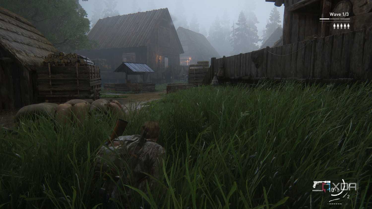 A screenshot from the game The Last of Us Part II Remastered on PC, showing Bill crawling through grass near mist-laden wooden houses.