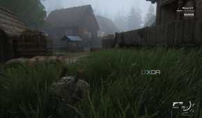 A screenshot from the game The Last of Us Part II Remastered on PC, showing Bill crawling through grass near mist-laden wooden houses.