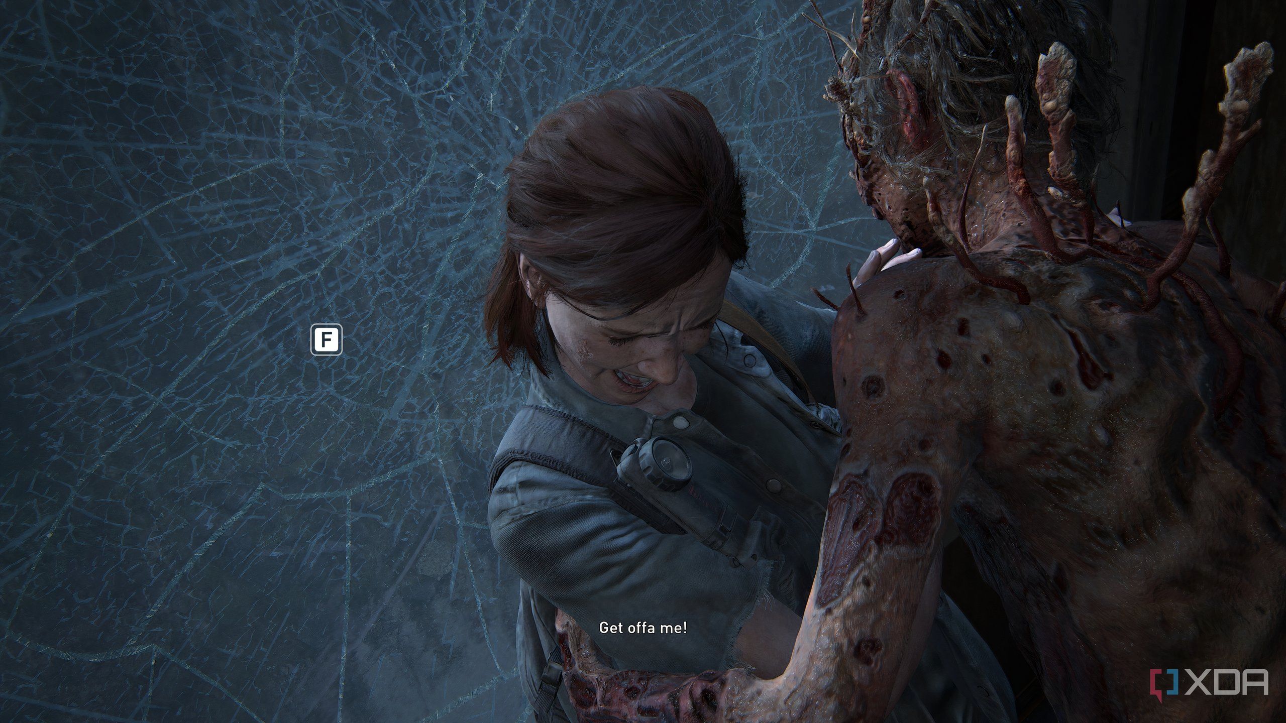 A screenshot from the game The Last of Us Part II Remastered on PC, showing a Stalker-type zombie enemy attacking Ellie and pushing her against shattering glass.