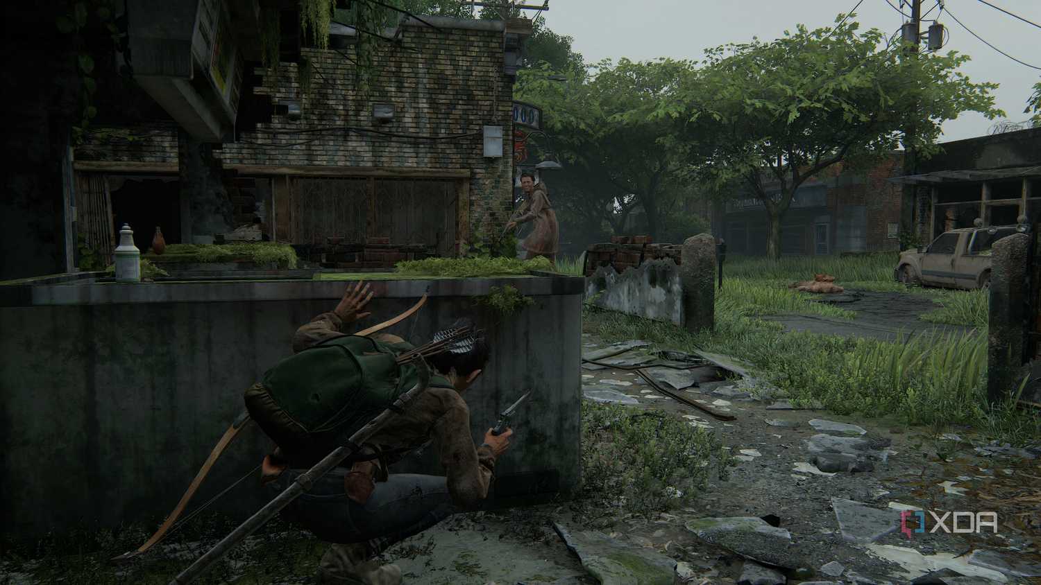 A screenshot from the game The Last of Us Part II Remastered on PC, showing Dina crouching in cover while an enemy with a bow patrols nearby.