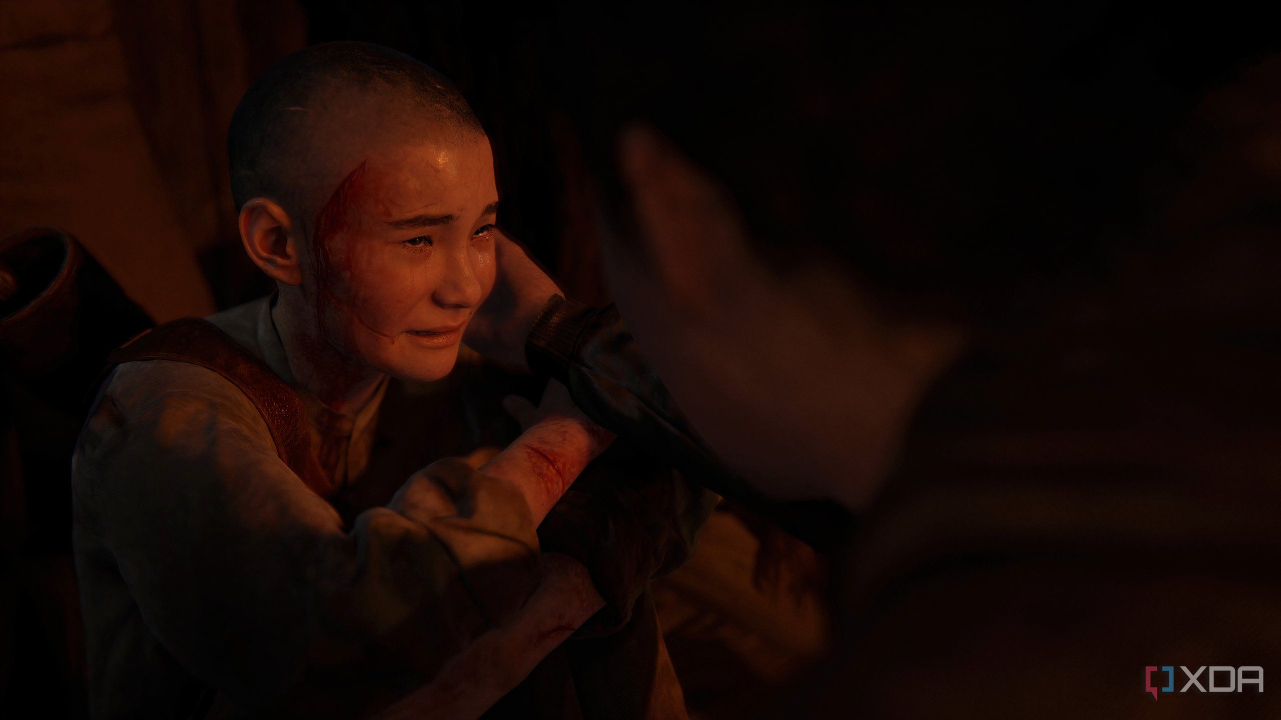 A screenshot from the game The Last of Us Part II Remastered on PC, showing a young Lev crying.