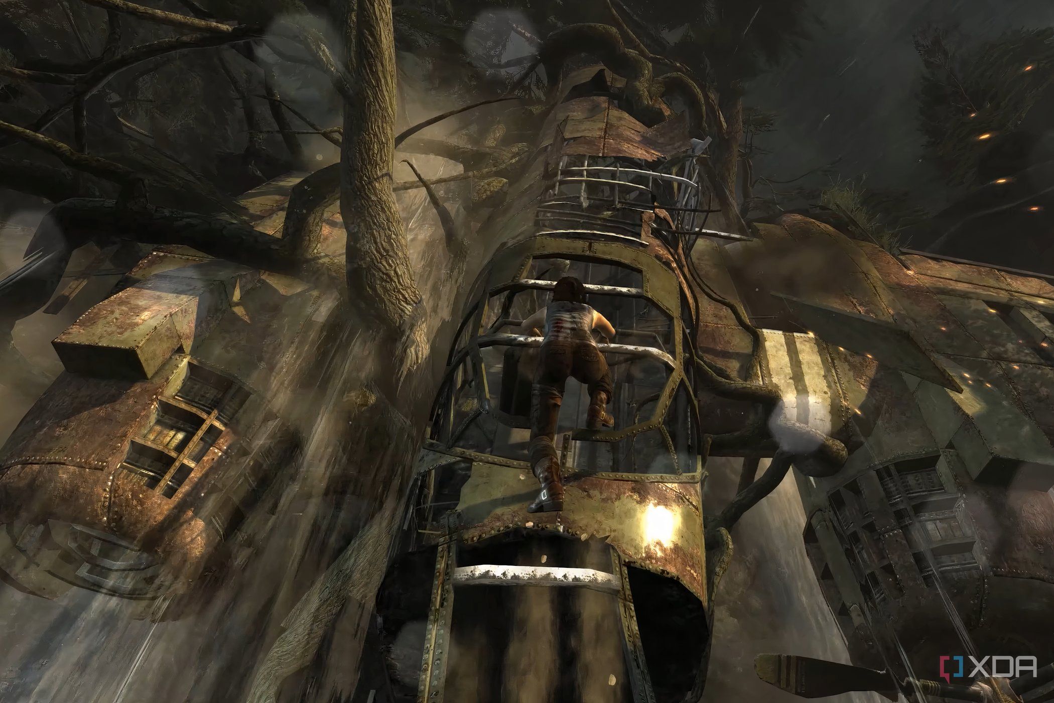 A screenshot from the 2013 game Tomb Raider, showing Lara Croft climb up a dilapidated metal plane.