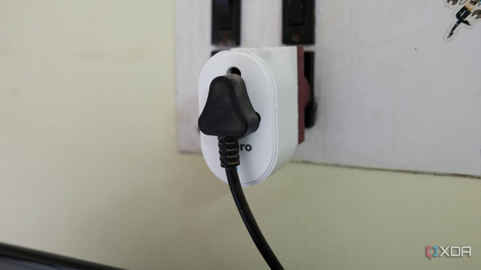Photo of a TV plug inserted into a smart plug which is put on a wall outlet for smart home automation