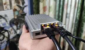 A person holding a ZimaBoard 2, with two Ethernet cables plugged into the SBC