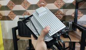 A person holding a ZimaBoard 2 alongside two drives