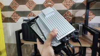 A person holding a ZimaBoard 2 alongside two drives