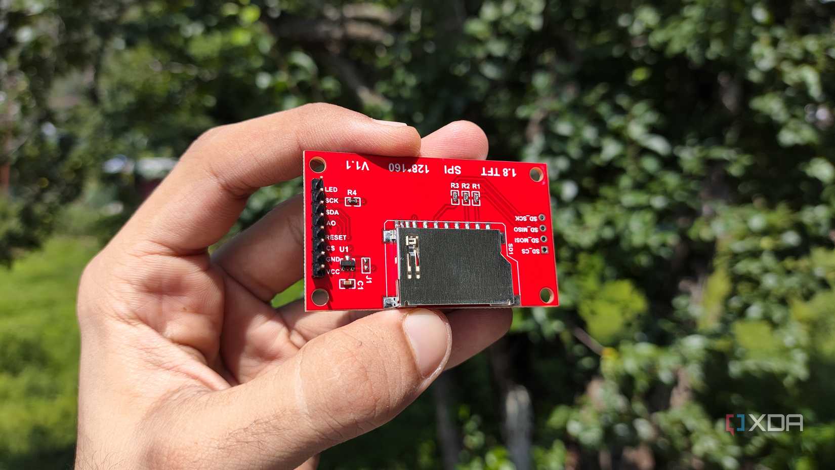 A person holding an ESP32 display module