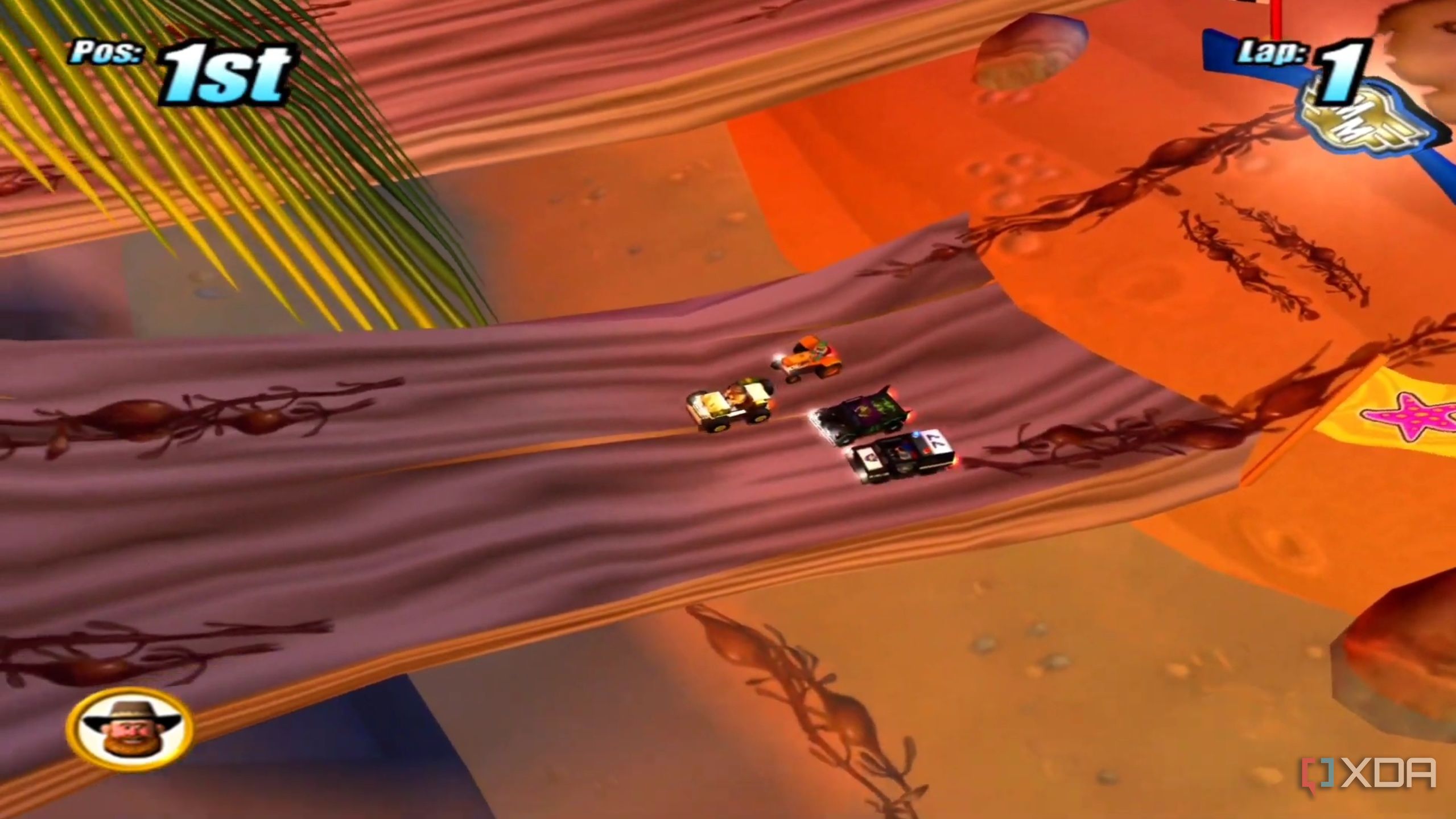 A screenshot from the game Micro Machines, showing a top-down view of four cars racing each other in the game.