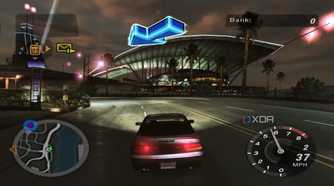 A screenshot from the game Need for Speed: Underground 2, showing a car speeding down the road while a big blue arrow points the way forward.