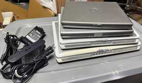 Stack of old laptops and power supplies
