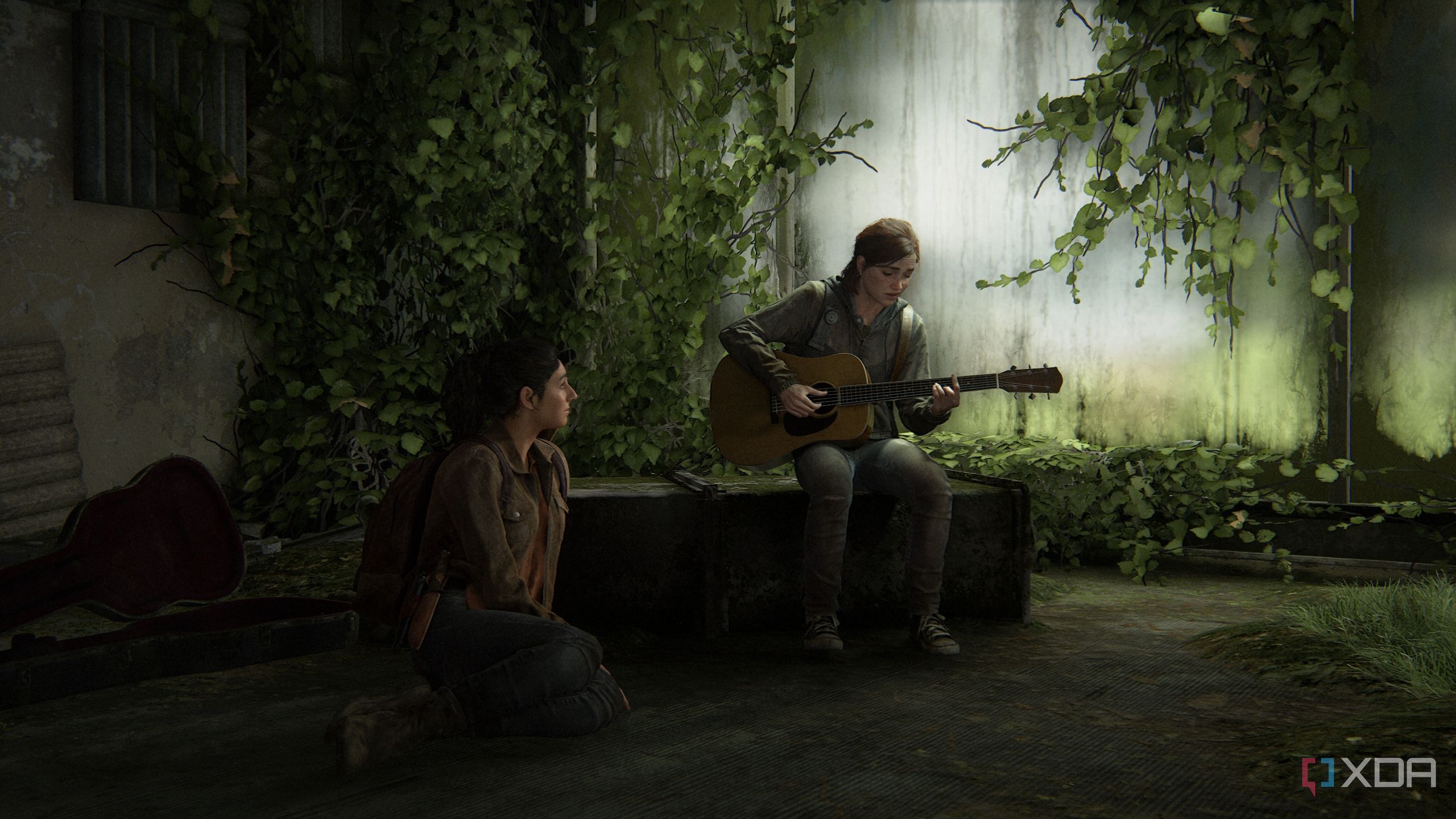 Ellie playing the guitar while Dina sits on the floor, listening.