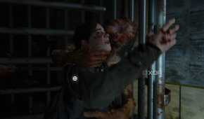 An image from the game The Last of Us Part II Remastered on PC, showing a clicker attacking Ellie through a revolving gate.