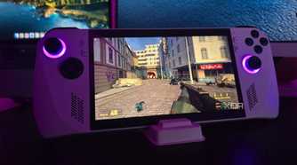 Asus ROG Ally running Half-Life 2 with a MacBook and a monitor in the background