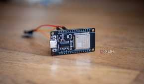 An ESP32 on a table, showing a vibration sensor connected with jumper cables