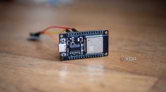 An ESP32 on a table, showing a vibration sensor connected with jumper cables