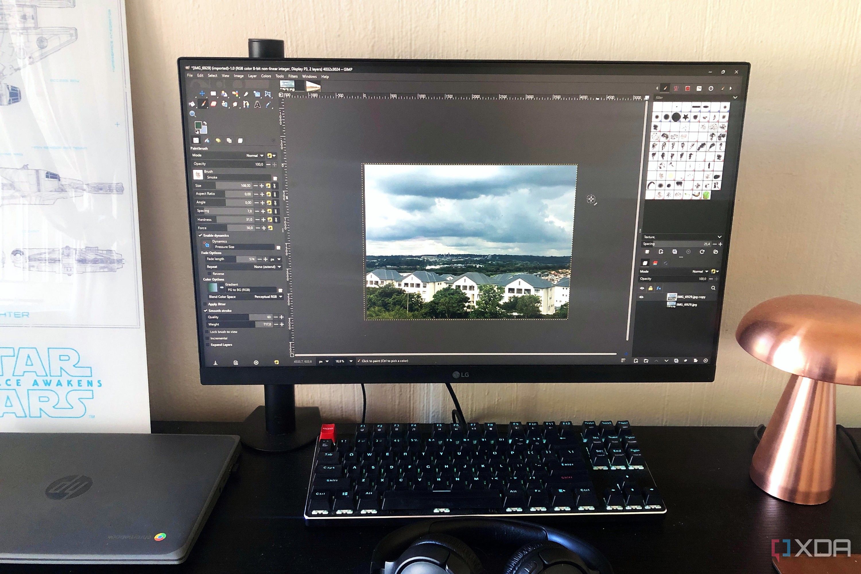 GIMP displayed on desktop pc, cityscape image, lamp and chromebook in view