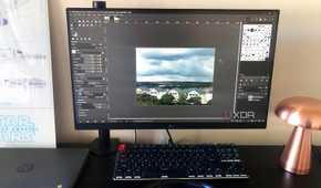 GIMP displayed on desktop pc, cityscape image, lamp and chromebook in view