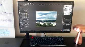 GIMP displayed on desktop pc, cityscape image, lamp and chromebook in view