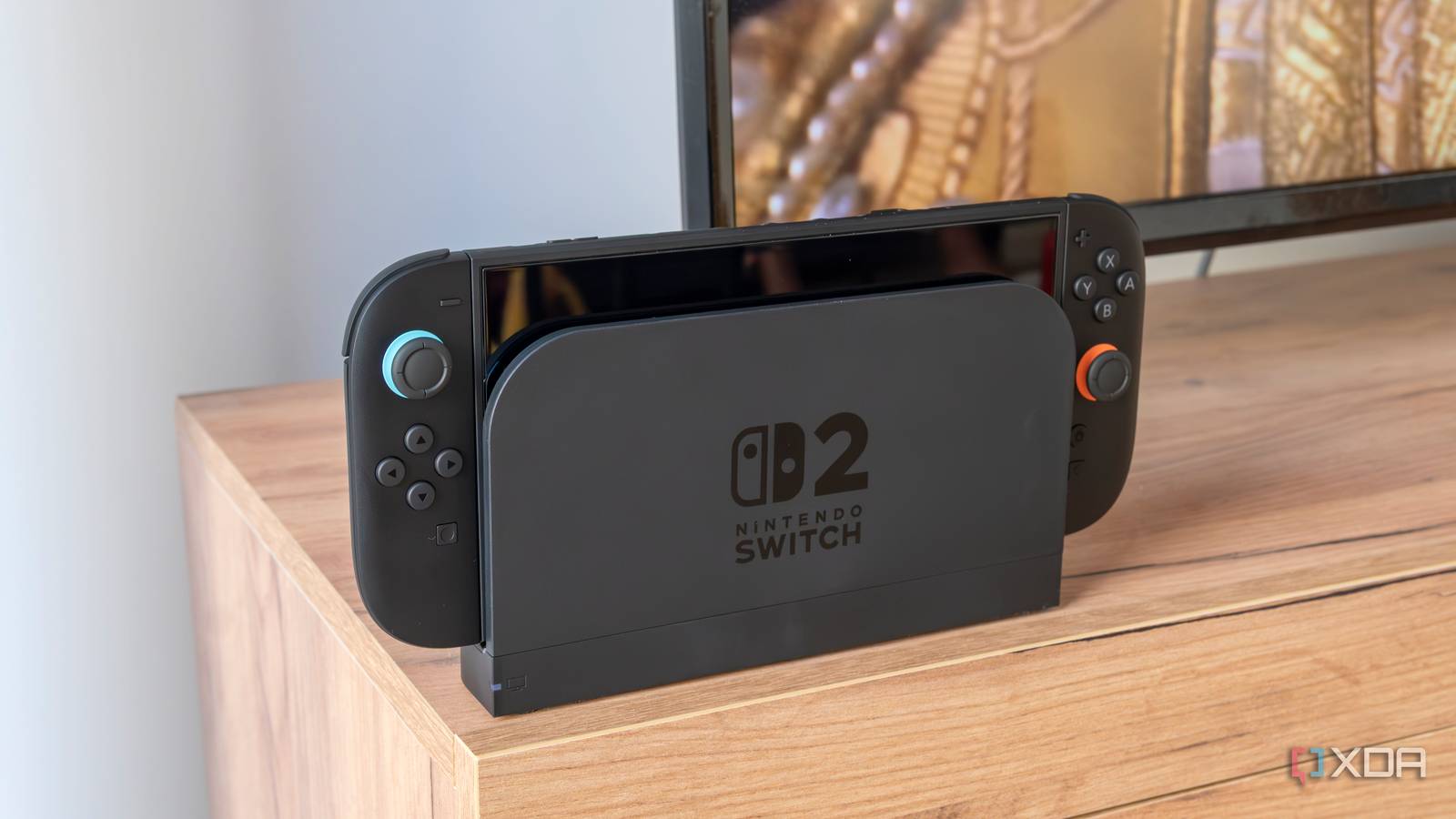 A Nintendo Switch 2 in its dock in front of a TV