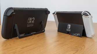 Angled rear view of a Nintendo Switch 2 and a Nintendo Switch OLED model showing both kickstand in use