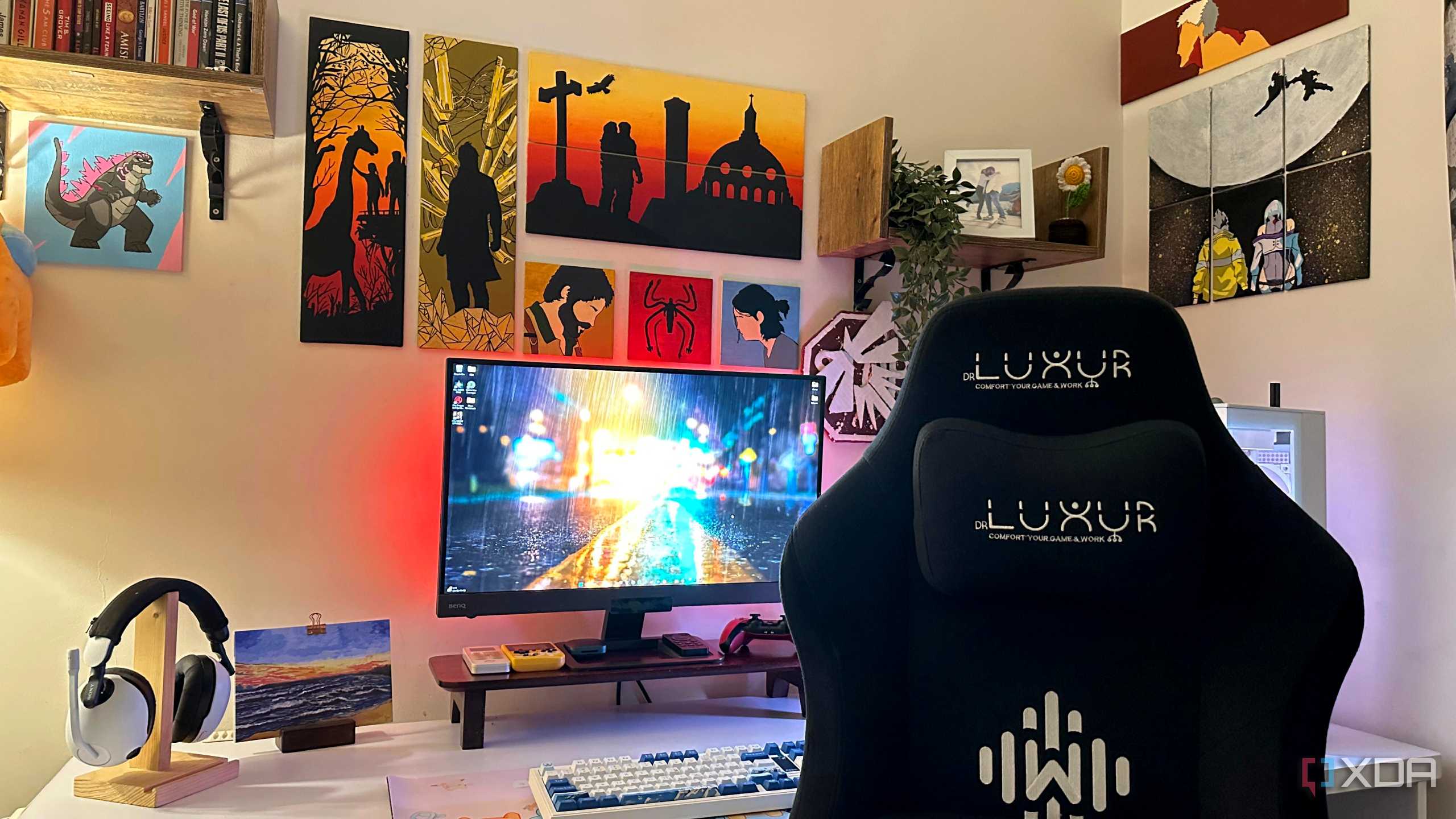 A gaming PC and gaming chair with video game art paintings on the wall.