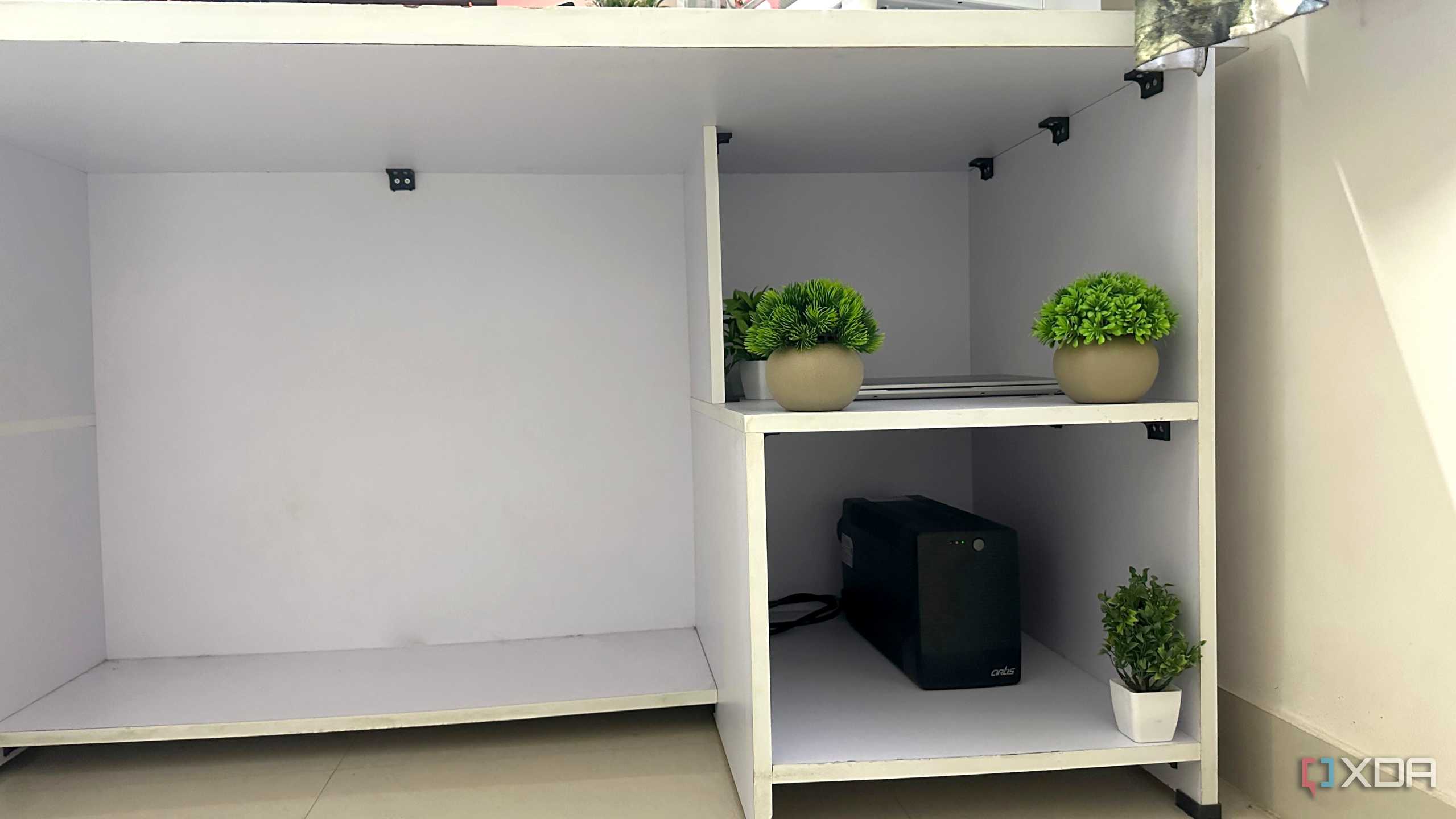 An image of a white computer table with sectioned compartments.