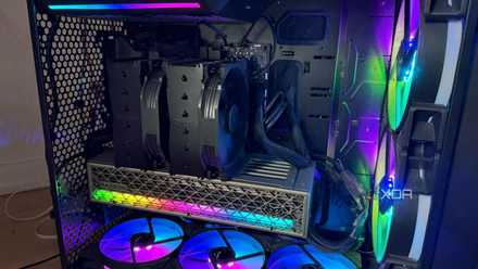 A photo of a PC turned on with RGB lights and an air cooler.