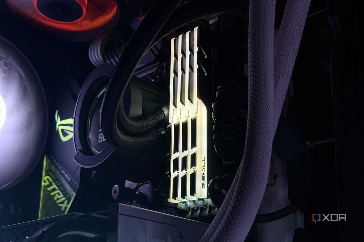 An image of an RGB DDR4 RAM kit installed on a motherboard illuminated in a yellow glow.
